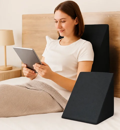 Woman reading in bed supported by the orthopedic wedge pillow